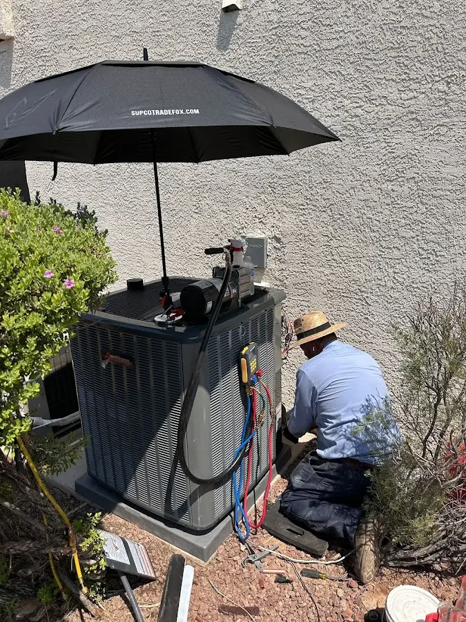 HVAC technician performing outdoor AC maintenance in Hesperia